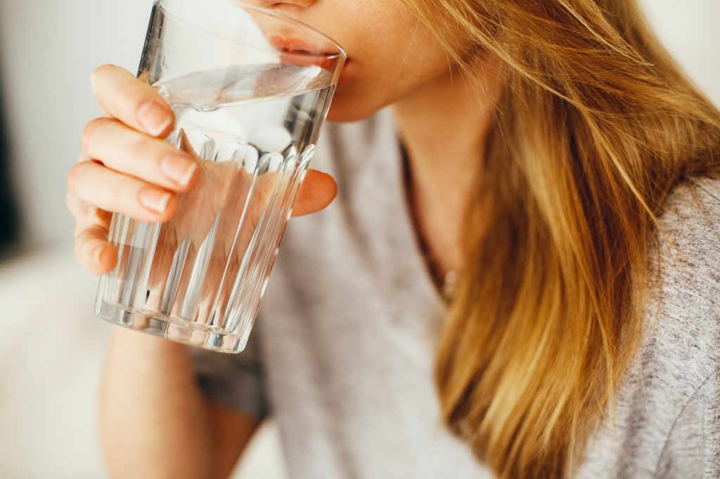 a woman holding a glass of water