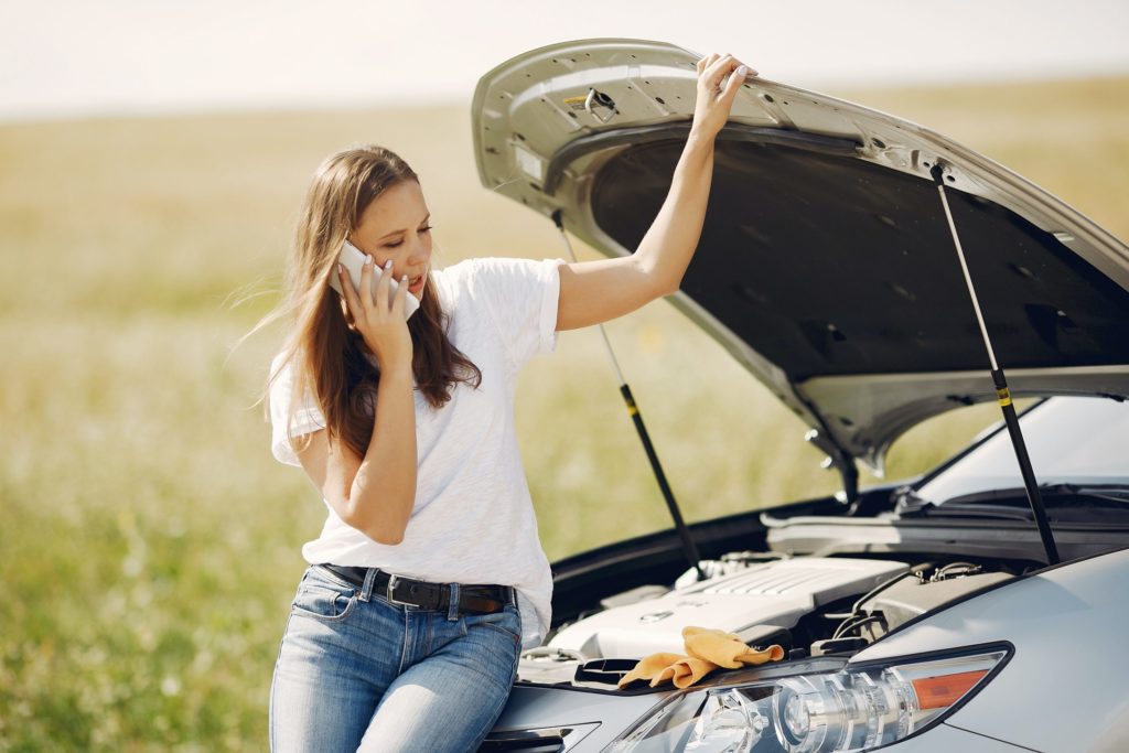 a woman standing next to a car