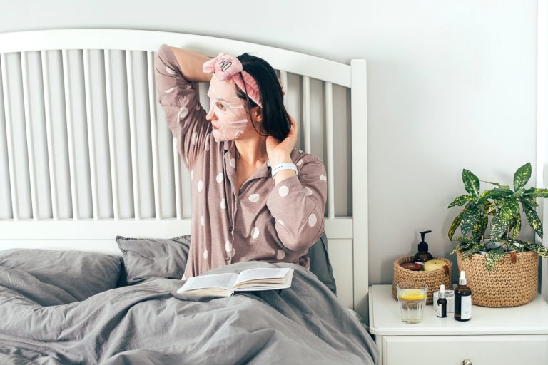 a person wearing a mask and sitting on a bed