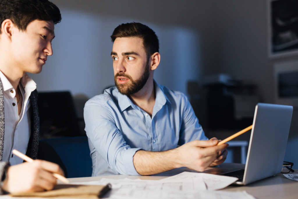 a man and a woman looking at a laptop