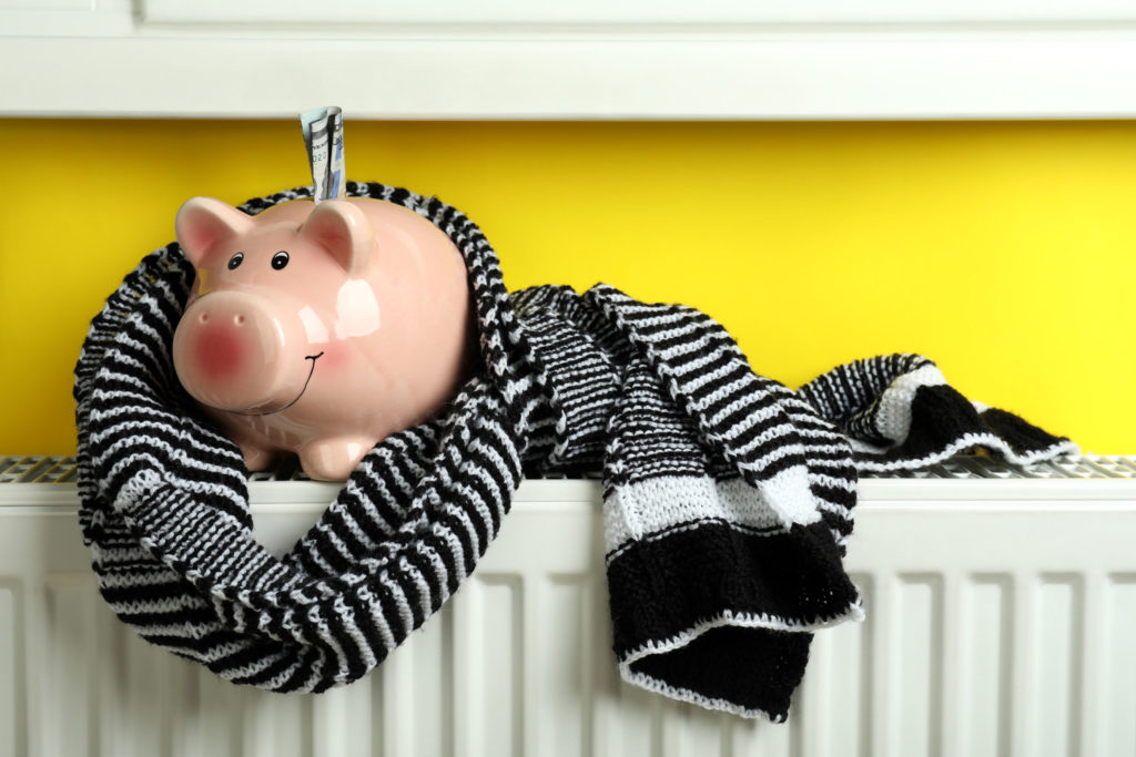 Concept of heating season with piggy bank on radiator